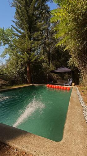 a pool of water with a gazebo in a yard at Glamping, Piscina, Río y Bosque - Más Líderes Experiencias in Santiago