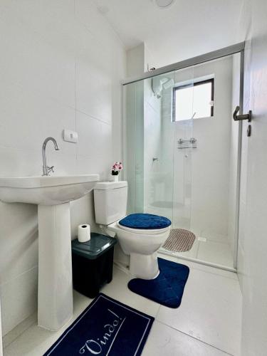 a bathroom with a toilet and a sink and a shower at Praia e Sol em Caiobá! in Matinhos