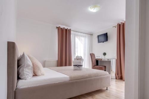 a white bedroom with a bed and a window at Oana Boutique C D I in Bran