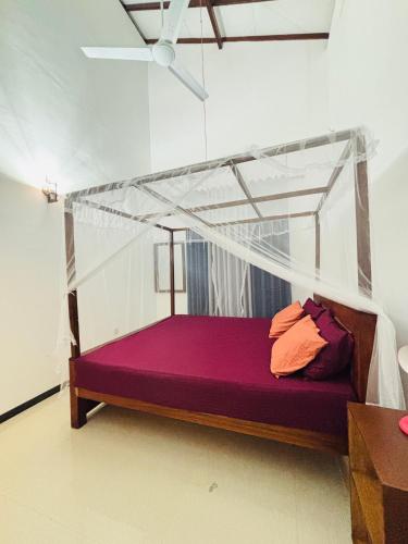 a bed with a canopy in a room at The Pearl Heaven in Dickwella