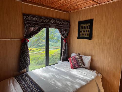 a bed in a room with a window at Bản Sù in Sapa
