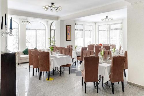 a dining room with white tables and brown chairs at Oana Boutique C D I in Bran