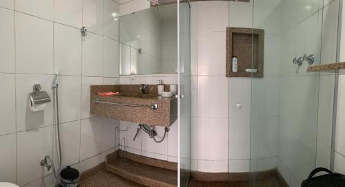 a bathroom with a shower with a sink and a mirror at Casa Indaiá in Petrópolis