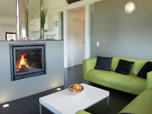 a living room with a green couch and a fireplace at Luxury Apartment in Malmedy with bubble bath in Malmedy
