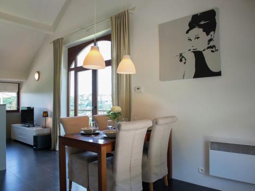 una sala da pranzo con tavolo e sedie e una stanza con finestra di Luxury Apartment in Malmedy with bubble bath a Malmedy