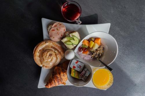 Un plato de comida con pan y fruta y una copa de vino. en Bettenburg Hotel Hamburg, en Hamburgo