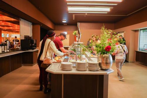 un grupo de personas preparando comida en un buffet en Bettenburg Hotel Hamburg, en Hamburgo