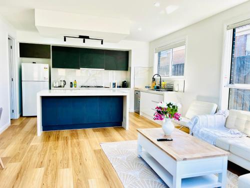 a kitchen and living room with a couch and a table at Modern 4 Bed 4 Bath Family friendly Villa in Melton South