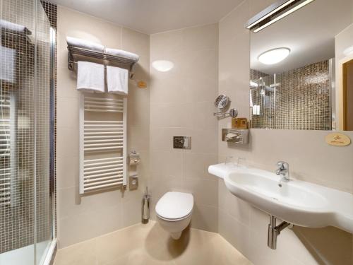 a bathroom with a toilet and a sink and a shower at Clarion Congress Hotel Ostrava in Ostrava