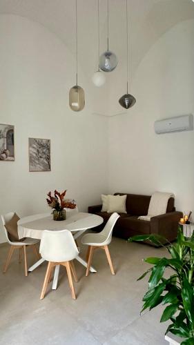 een woonkamer met een tafel, stoelen en een bank bij Nina Mia in Fasano