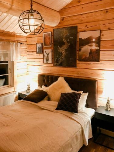 a bedroom with a large bed in a wooden wall at Mountain-Close Cabin With Panoramic View in Sälen