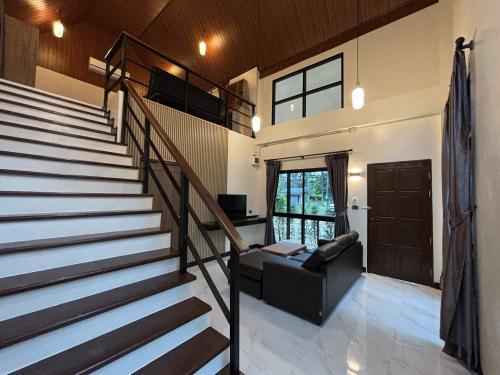 a living room with a staircase and a couch at Ao Thong beach Resort in Khao Lak