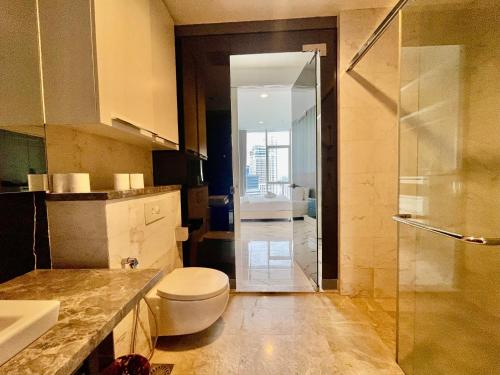 a bathroom with a toilet and a glass shower at Platinum Grand Stay Kuala Lumpur in Kuala Lumpur