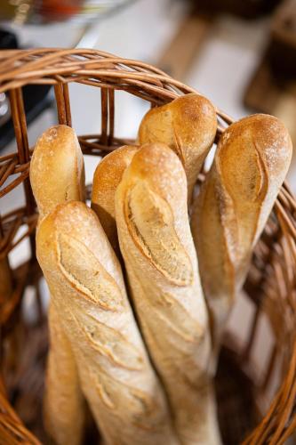 a basket filled with lots of loaves of bread at Logis Hôtel Domaine du Moulin Cavier - Restaurants & Spa in Avrillé