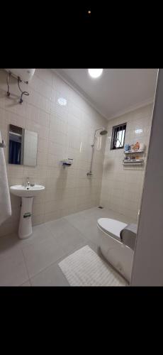 a bathroom with a shower and a toilet and a sink at SC Luxury Home in Dar es Salaam