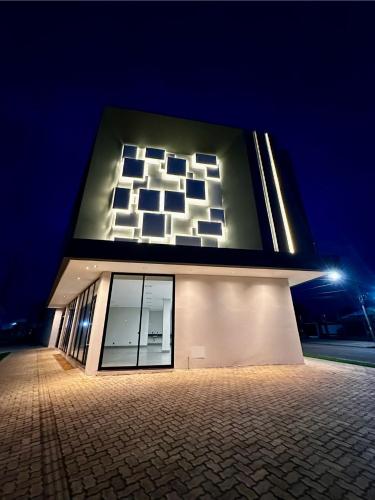 a building with a lit up facade at night at Lofts completos em Sinop MT in Sinop