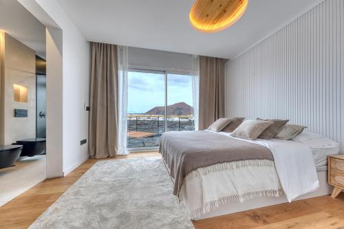 a bedroom with a large bed and a large window at Chalet Cueva del Sol in Tahiche