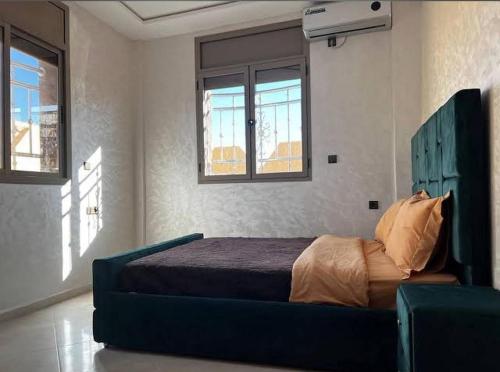 a bedroom with a bed in a room with windows at Sahara luxury suites in Hassilabied