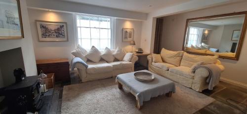 a living room with two couches and a mirror at Binswood Garden Apartment in Leamington Spa