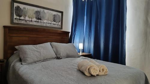 a bed with a towel laying on top of it at Depto en condo, 1D 1B, aire estacionamiento, full in Curicó