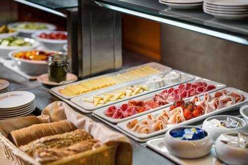 Una línea de buffet con diferentes tipos de comida en bandejas. en Clarion Congress Hotel Ostrava, en Ostrava