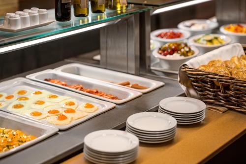 Una línea de buffet con bandejas de comida y platos. en Clarion Congress Hotel Ostrava, en Ostrava
