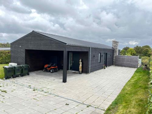 a black garage with a tractor inside of it at Holiday Idyll With Nature And City Nearby in Skødstrup