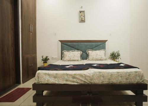 um quarto com uma cama grande com cabeceira verde em Hare Krishna Homestay em Agra