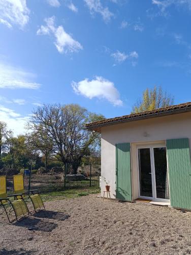 a house with two chairs sitting outside of it at Appartement en maison d'hôtes in Badens
