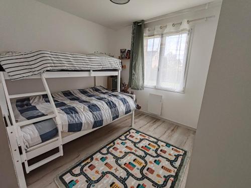 a small bedroom with a bunk bed and a rug at Gîte De L 'entre 2 Côtes in Vindefontaine