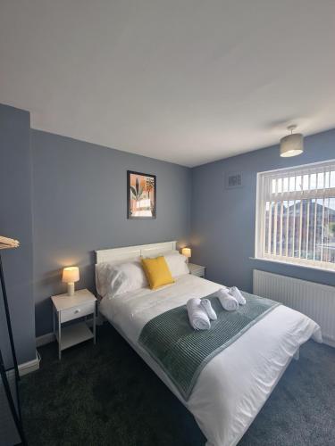 a bedroom with a large bed with towels on it at Bright & cosy 3-bed semi in Wheatley, Doncaster in Arksey