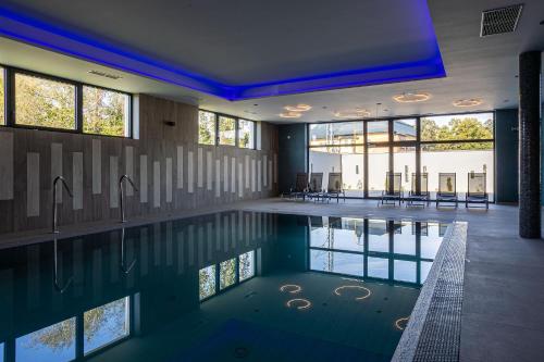 a swimming pool in a house with windows and a swimming pool at Hotel Alibaba in Humenné