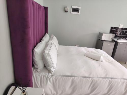 a bed with white sheets and pillows in a room at Khaya guesthouse in Rustenburg