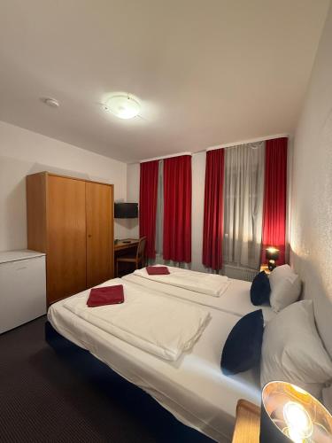 a hotel room with a large bed with red curtains at Hotel Nassauer Hof Frankfurt in Frankfurt/Main