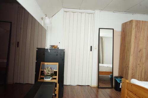 um quarto com um espelho e uma geladeira preta em Upstairs include bedroom, and living room em Hyvinkää