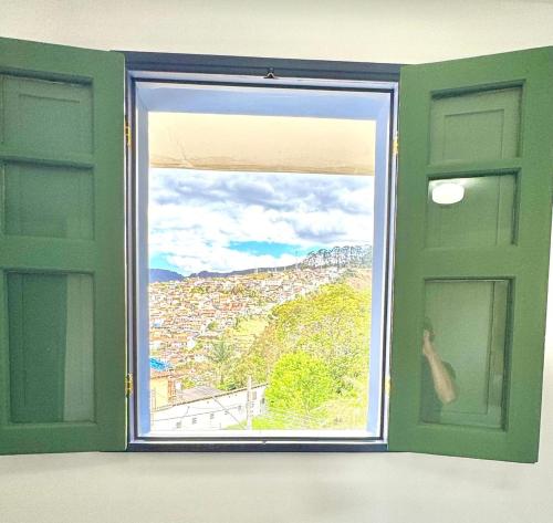 an open window with a view of a city at Casa Charmosa no Centro Histórico in Ouro Preto