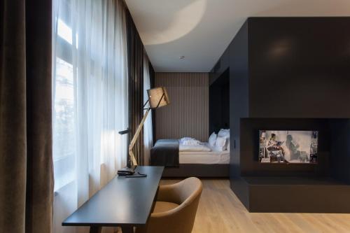 a hotel room with a desk and a bed at Ilonn Boutique Limanowskiego in Poznań