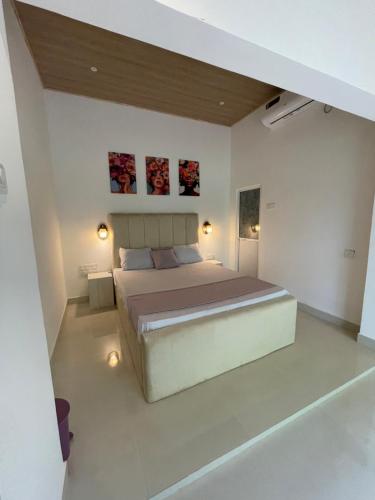 a bedroom with a large bed and two paintings on the wall at Dambulla Village Stay in Dambulla