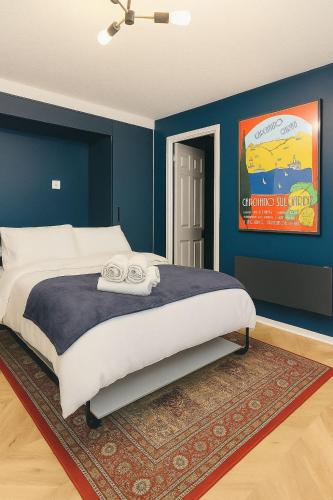 ein Schlafzimmer mit einem großen Bett mit blauen Wänden in der Unterkunft Studio Flat - Near Oxford Street in Southampton