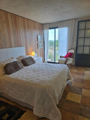 ein Schlafzimmer mit einem großen Bett und einem Stuhl in der Unterkunft Tornasole,reserva natural,La granja,Cordoba in La Granja