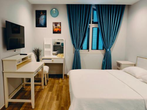 Un dormitorio con dos camas y un escritorio y un televisor. en SUN House, en Phu Quoc