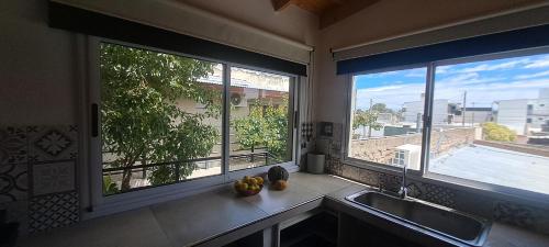 a kitchen with two large windows and a kitchen sink at Loft Moderno in Viedma