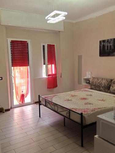 a bedroom with a bed and two windows with red curtains at Eros casa in Milan