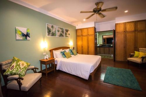 une chambre avec un lit et une chaise dans une pièce dans l'établissement Villa Oriole - Luxury Pool Villa, à Layan Beach