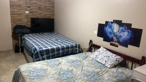 a room with two beds and a painting on the wall at Casa Mar in Guaratuba