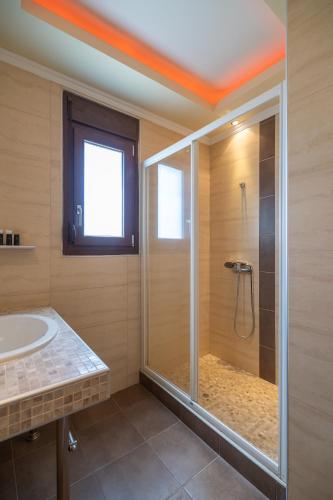 a bathroom with a shower with a glass door at Meliton Inn Hotel & Suites by the beach in Neos Marmaras