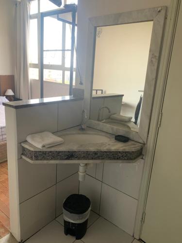 a bathroom with a sink and a mirror at Kit Dom José in Araxá