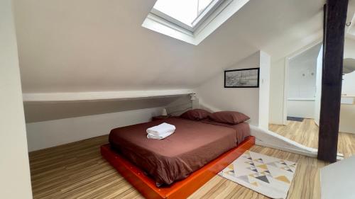 a small bedroom with a bed in a attic at Duplex Beauvoisine in Rouen