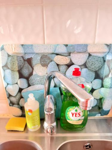 NybodaにあるSwedish Beach House in Stockholm Archipelago, Skärgårdsstuga i Roslagenのタイル壁のキッチンにある蛇口付きのシンク