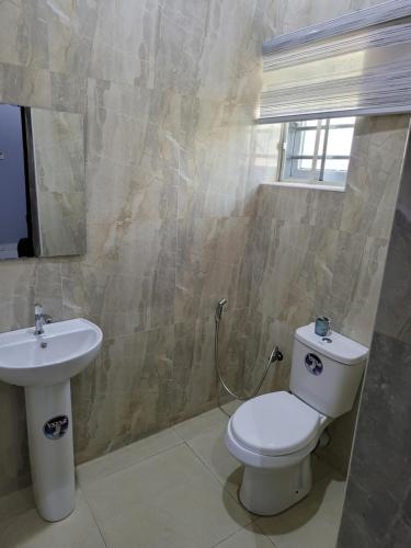 un baño con inodoro y lavabo en Danamic view hotel, en Abuja